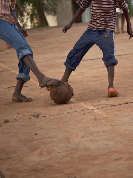 Kinder spielen in Ruanda Fußball auf der Straße.