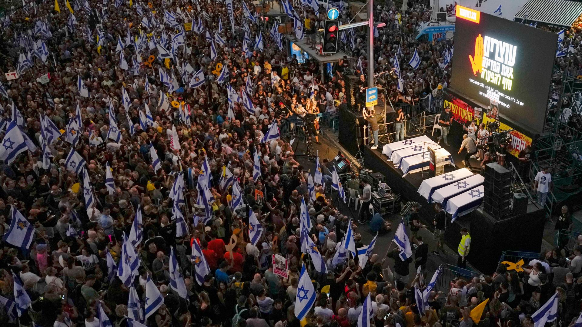 Tel Aviv: Menschen fordern während einer Demonstration die sofortige Freilassung von Geiseln, die im Gazastreifen von der militanten Hamas-Gruppe festgehalten werden. Symbolisch werden sechs Sarge mit der israelischen Flagge auf einer Bühne gezeigt. 