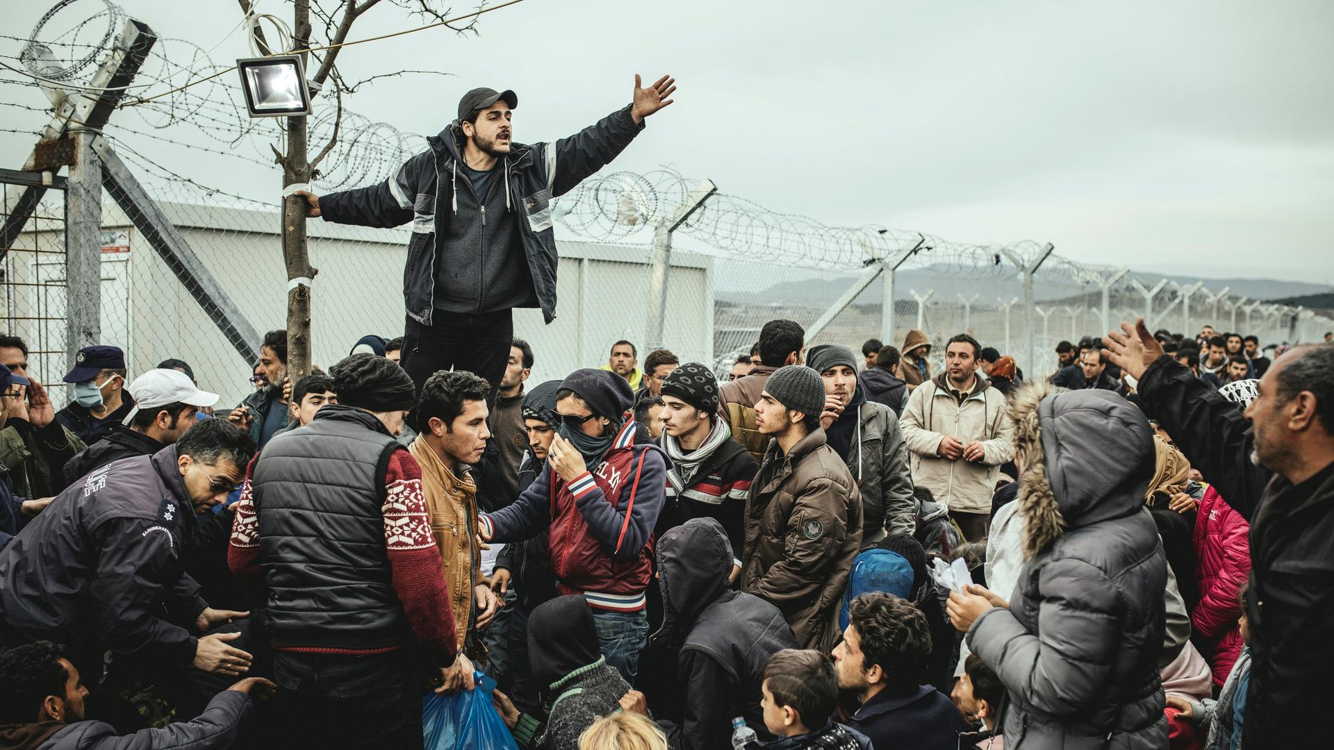 Flüchtlingslager Idomeni an der griechisch-mazedonischen Grenze, wartende Flüchtlinge am Checkpoint, ein Mann übersetzt die offiziellen Informationen.