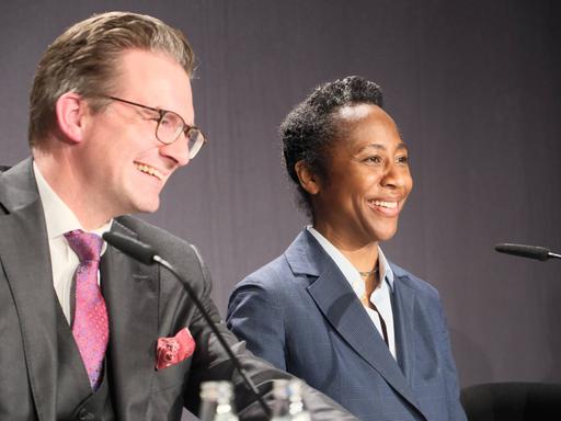 Sven Schöller und Naomi Beckwith mit guter Laune auf dem Podium einer Pressekonferenz.