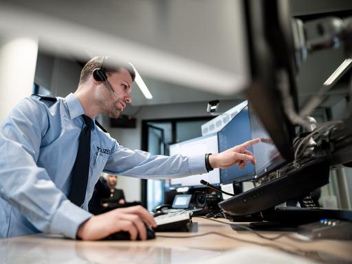 Ein Polizist zeigt auf einen Monitor. Er stellt ein neues GPS-Monitoring bei der Polizei in Mönchengladbach vor. Der Einsatz der Streifenwagen soll damit besser gesteuert werden.