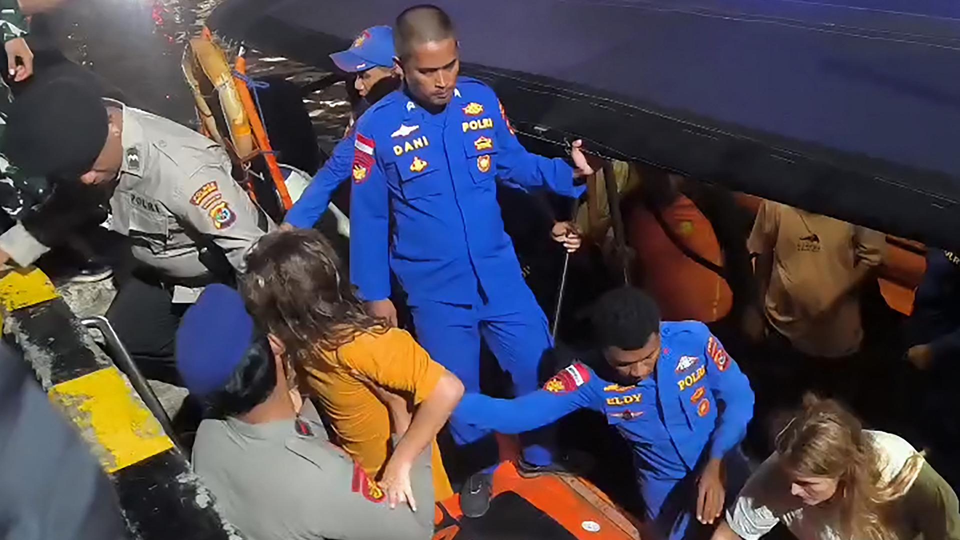 Indonesische Rettungsteams helfen Schiffbrüchigen aus einem Rettungsboot.