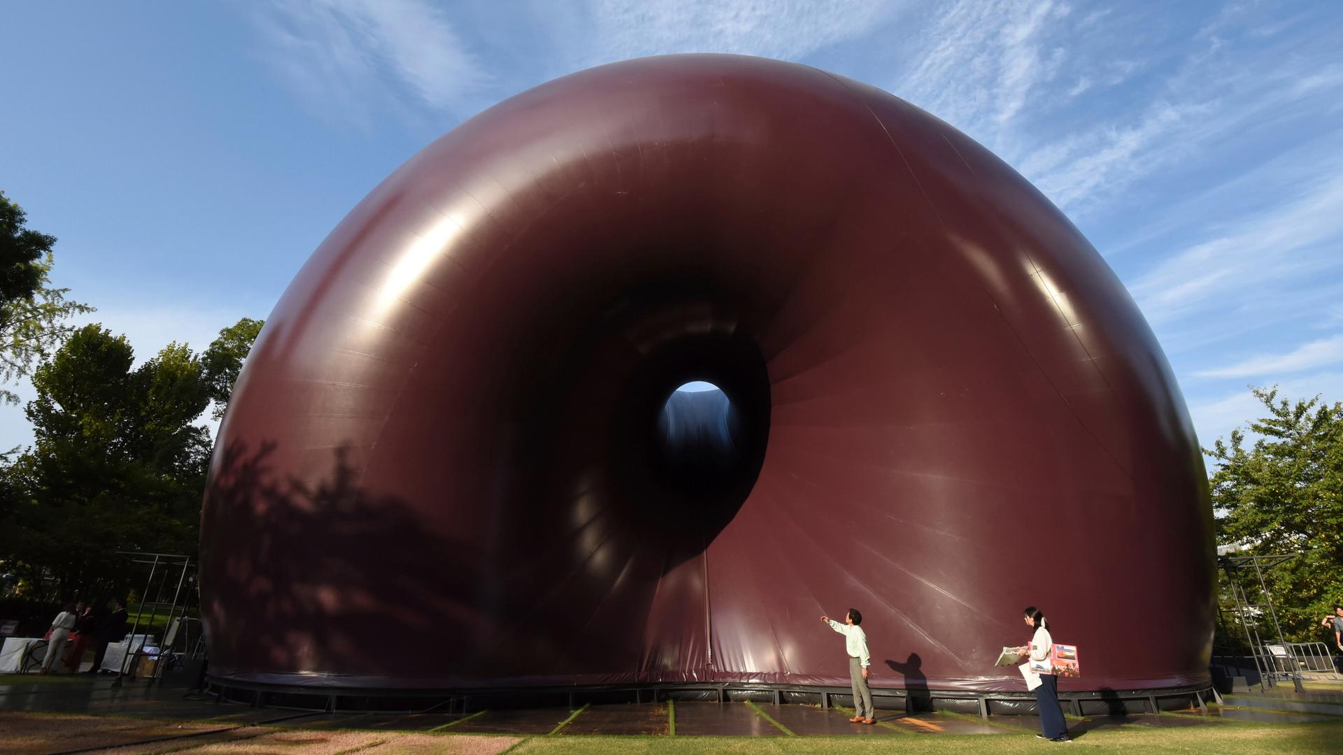Eine mobilem aufblasbare Konzerthalle mit lilafarbener Plastikhülle in Schneckenhausform in Tokio Eine mobilem aufblasbare Konzerthalle mit lilafarbener Plastikhülle in Schneckenhausform in Tokio