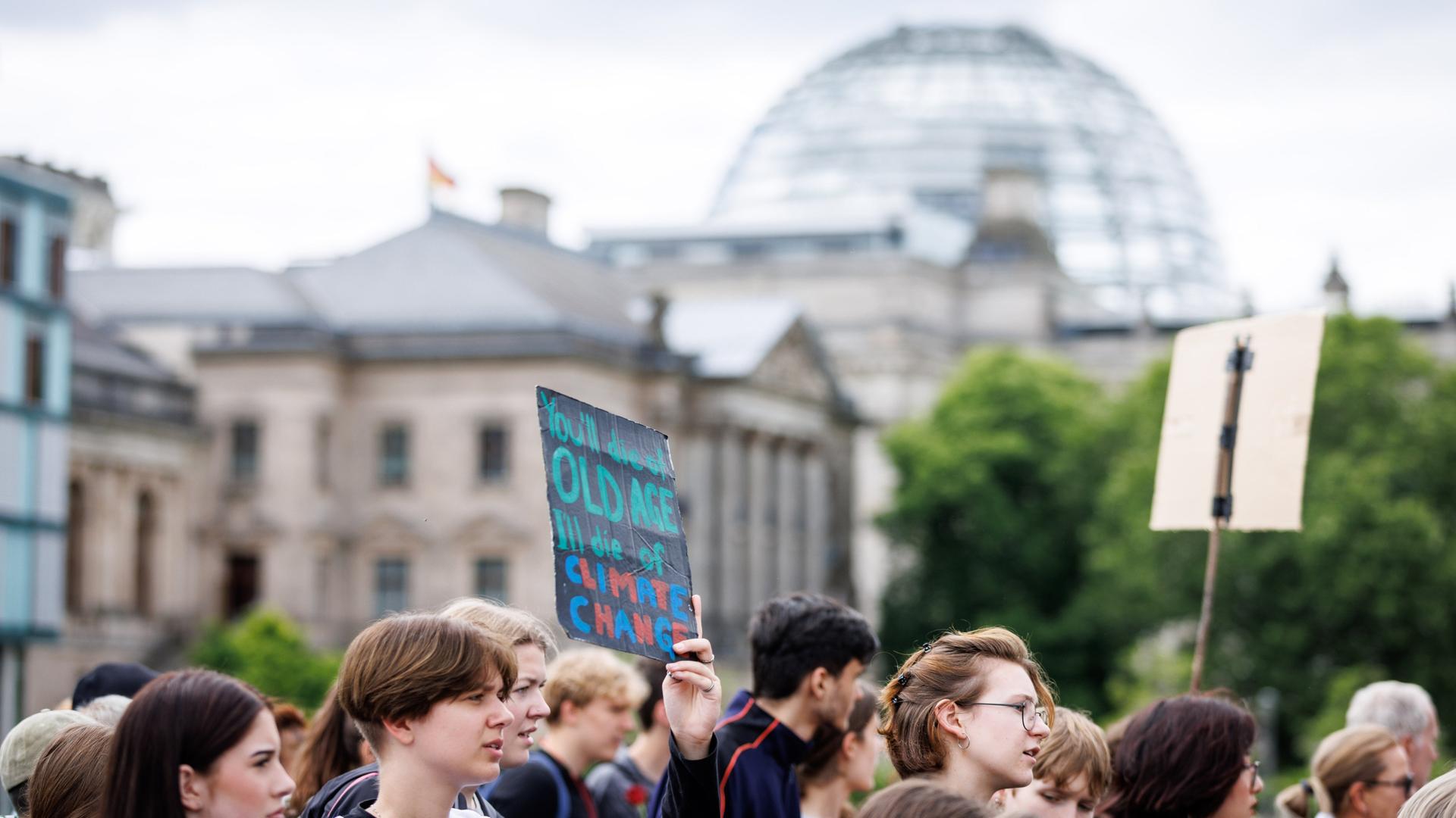 Demonstrierende mit Schildern sind am 31.05.2024 beim Klimastarik von Fridays for Future vor dem Reichstagsgebäude zu sehen.