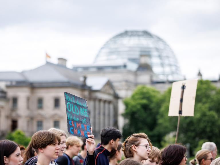 Demonstrierende mit Schildern sind am 31.05.2024 beim Klimastarik von Fridays for Future vor dem Reichstagsgebäude zu sehen.