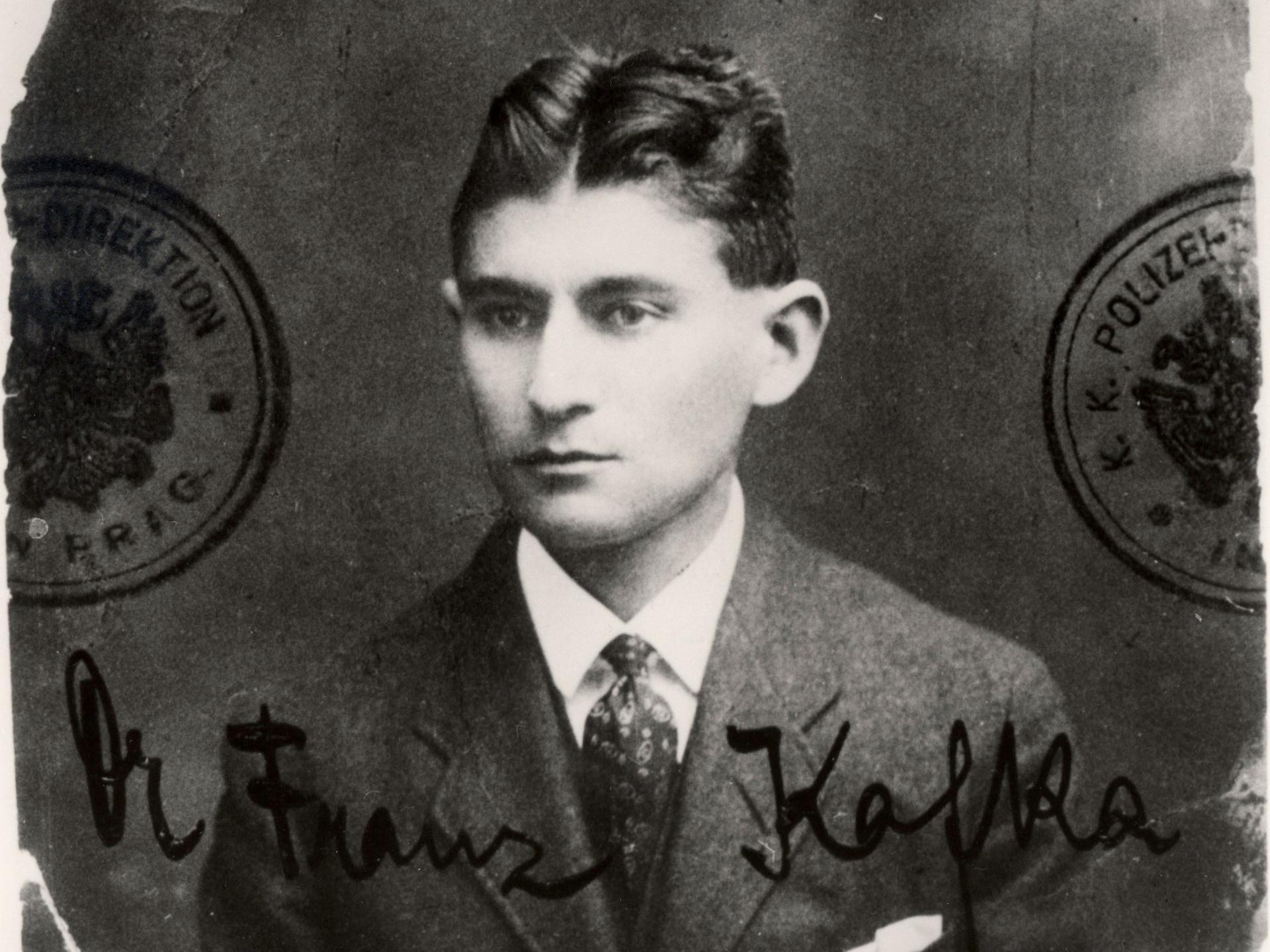 Ein schwarzweißes ausgefranstes Passfoto des jungen Schriftstellers Franz Kafka, der sehr ernst blickt