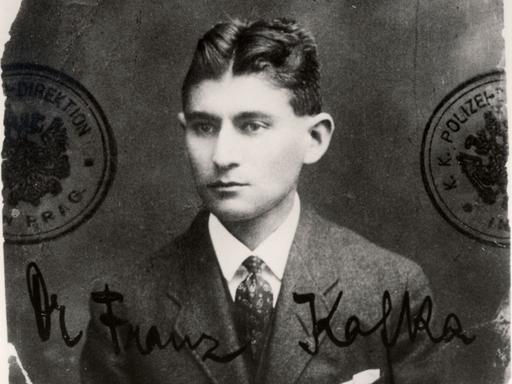 Ein schwarzweißes ausgefranstes Passfoto des jungen Schriftstellers Franz Kafka, der sehr ernst blickt