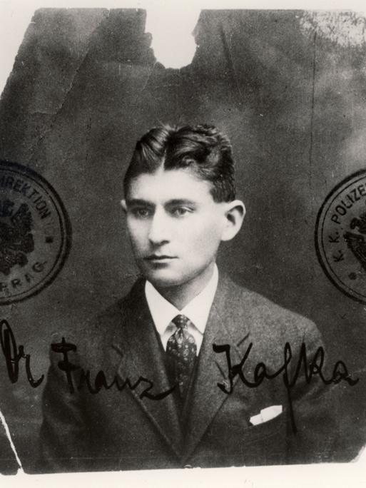 Ein schwarzweißes Passfoto zeigt Franz Kafka, der sehr ernst blickt. (Quelle: dpa)