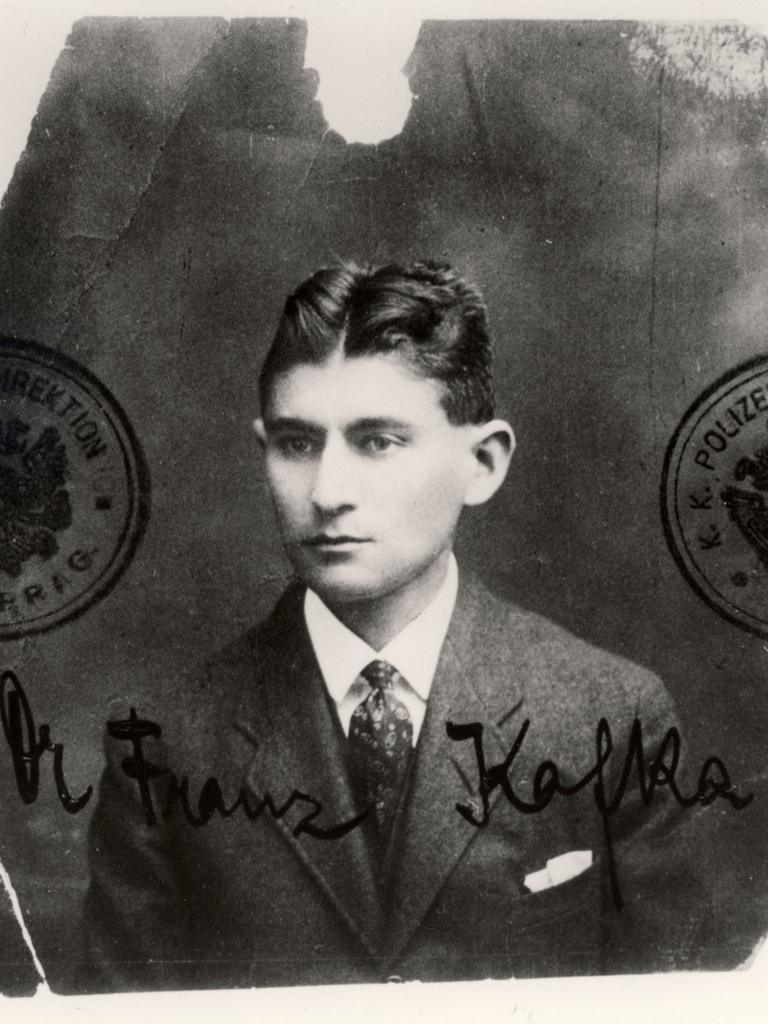 Ein schwarzweißes ausgefranstes Passfoto des jungen Schriftstellers Franz Kafka, der sehr ernst blickt