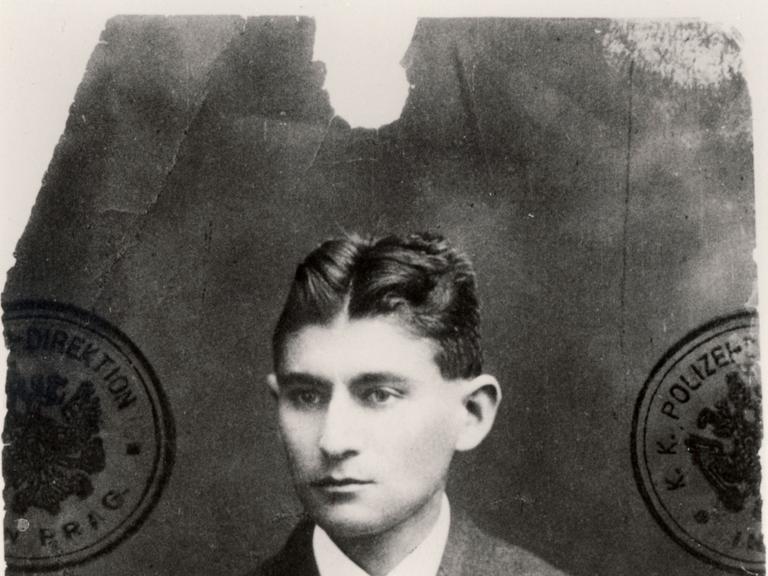 Ein schwarzweißes Passfoto zeigt Franz Kafka, der sehr ernst blickt. (Quelle: dpa)