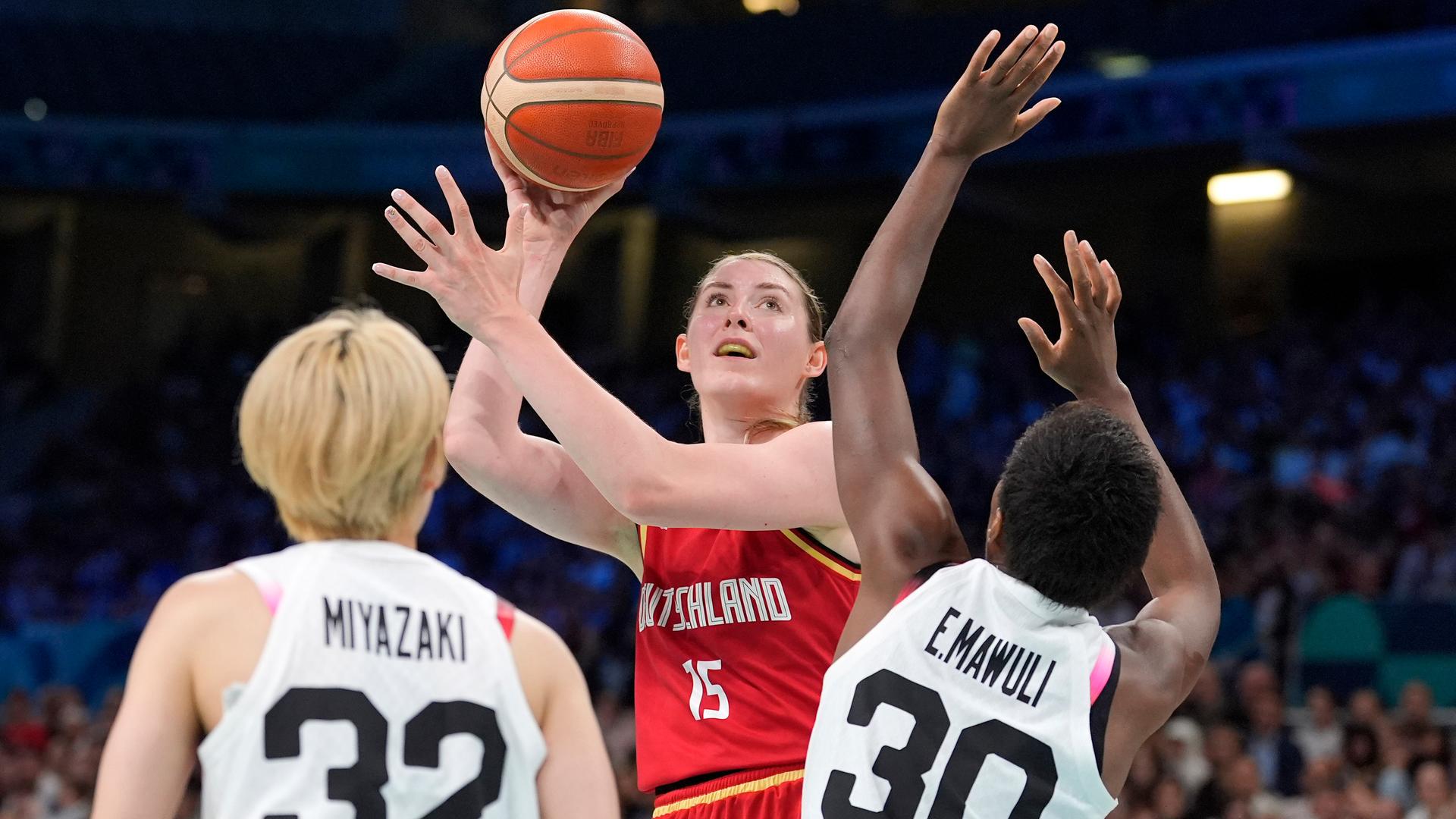 Eine Szene aus dem Basketballspiel der Frauen zwischen Deutschland und Japan. Luisa Geiselsode wirft einen Ball, zwei Japanerinnen versuchen, sie zu blocken.