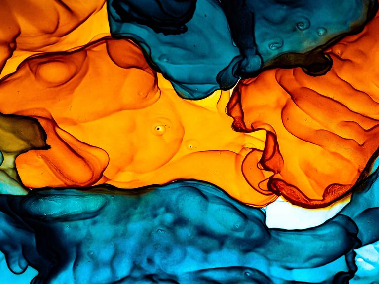 Abstrakte Alkoholmalerei in Orange und Blautönen.