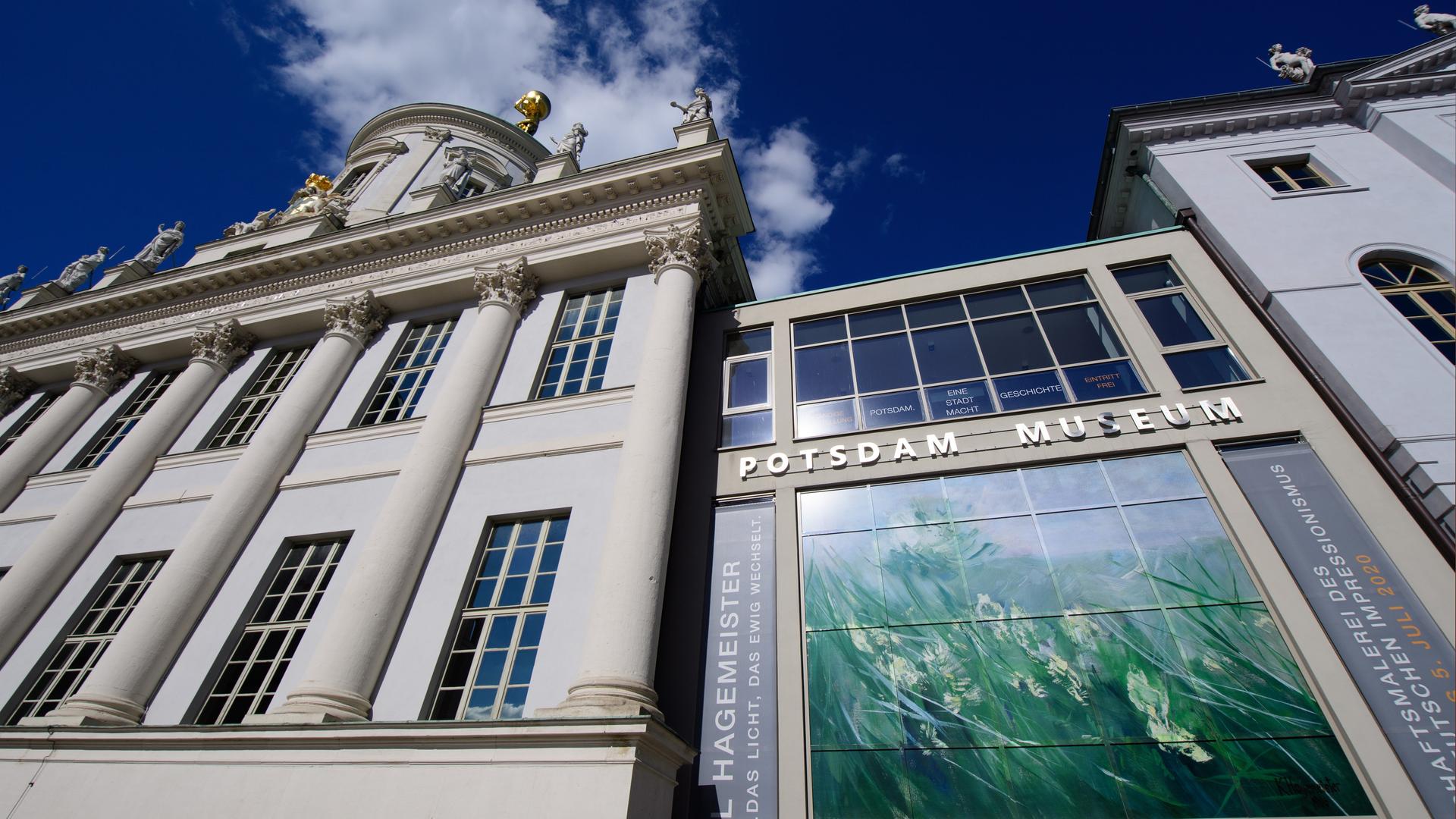 Die Außenansicht des Potsdam Museums aus der Froschperpektive zeigt die weiße Fassade mit Säulen und den Schriftzug "Potsdam Museums".