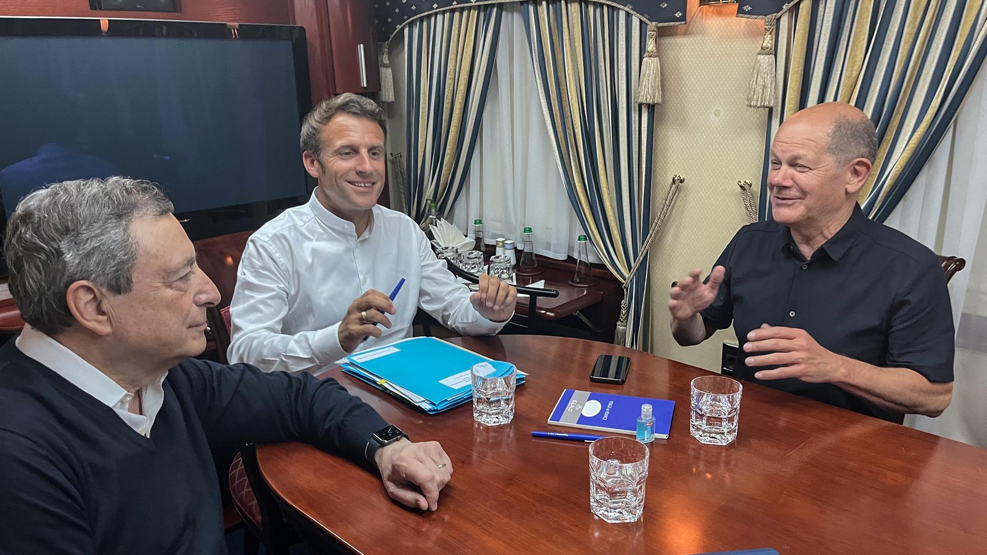 Italiens Ministerpräsident Mario Draghi (l-r), Frankreichs Präsident Emmanuel Macron und Bundeskanzler Olaf Scholz (SPD) sitzen Mitte Juni einem Salonwagen eines Zuges auf der Reise nach Kiew. 