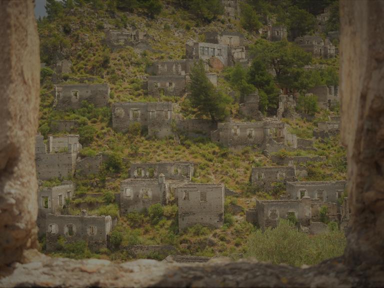 Ein verlassenes Dorf: Durch Steinmauern blickt man auf Ruinen.