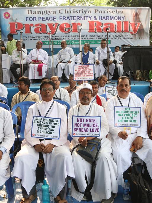 Indische Männer christlichen Glaubens protestieren mit Plakaten gegen christenfeindliche Gewalt im indischen Westbengalen.