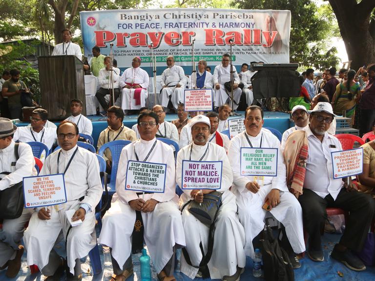 Indische Männer christlichen Glaubens protestieren mit Plakaten gegen christenfeindliche Gewalt im indischen Westbengalen.