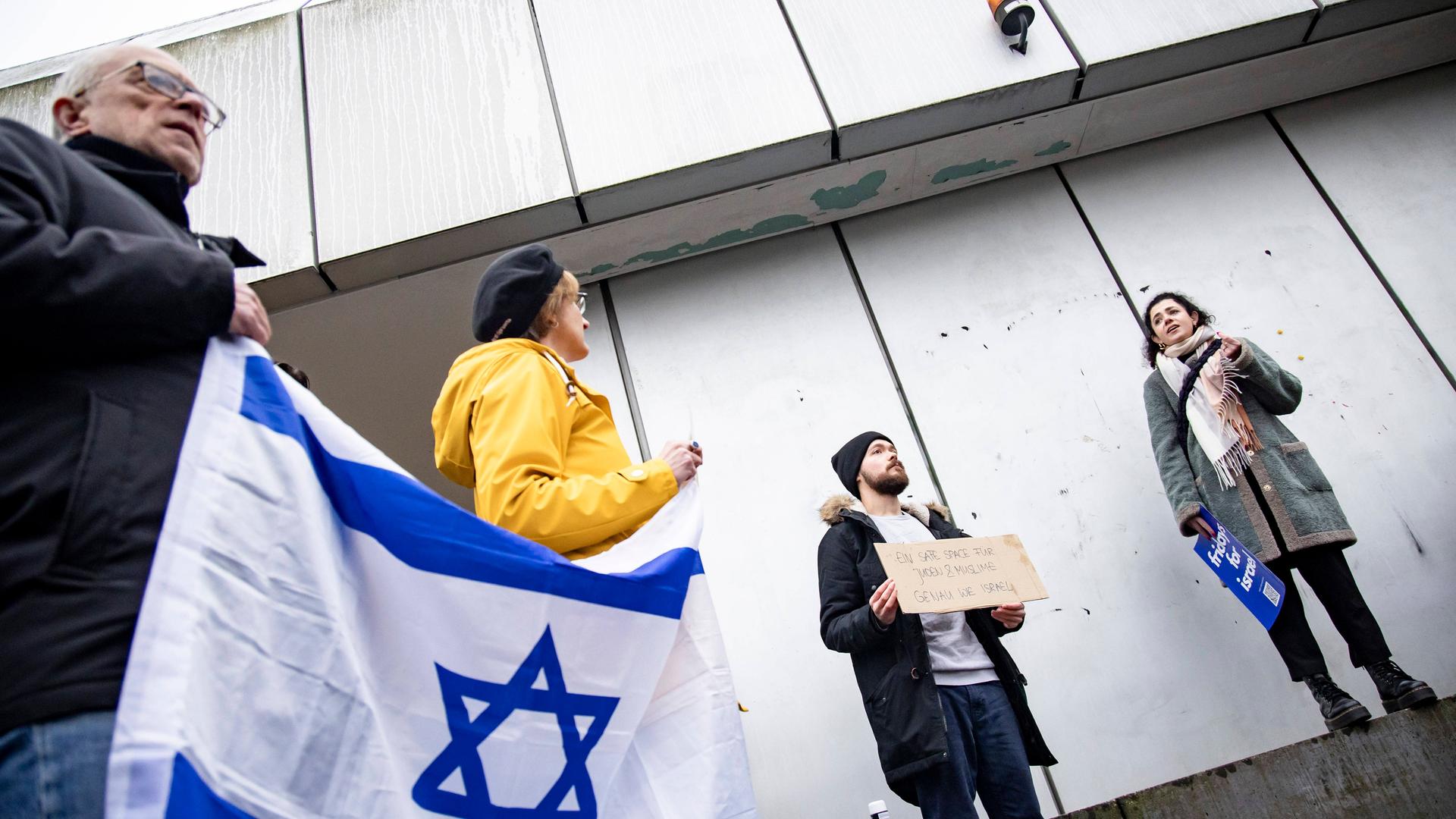 Aufnahme von schräg unten. Links eine Person, die eine Israel-Flagge hält. 