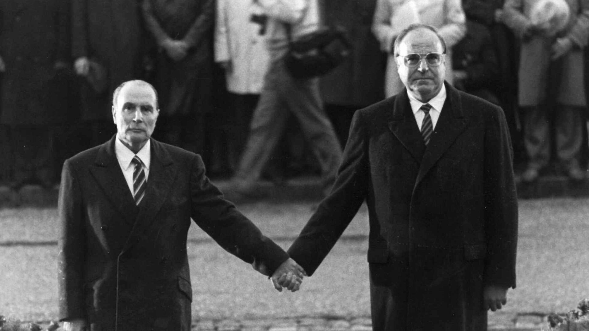Der frühere französische Präsident Francois Mitterrand und der deutsche Bundeskanzler Helmut Kohl stehen bei einer Feier zur deutsch-französischen Versöhnung am Friedhof Douaumont in der Nähe von Verdun