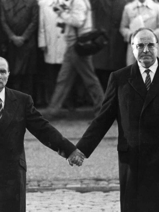 Der frühere französische Präsident Francois Mitterrand und der deutsche Bundeskanzler Helmut Kohl stehen bei einer Feier zur deutsch-französischen Versöhnung am Friedhof Douaumont in der Nähe von Verdun