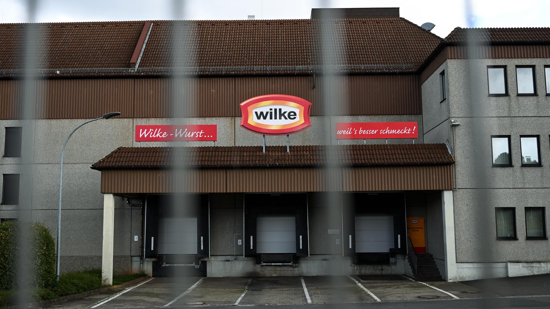 An der Fleischfabrik Wilke sind die Tore heruntergelassen, das zweckmäßige Gebäude ist durch einen Zaun fotografiert. An der Fleischfabrik Wilke sind die Tore heruntergelassen, das zweckmäßige Gebäude ist durch einen Zaun fotografiert.