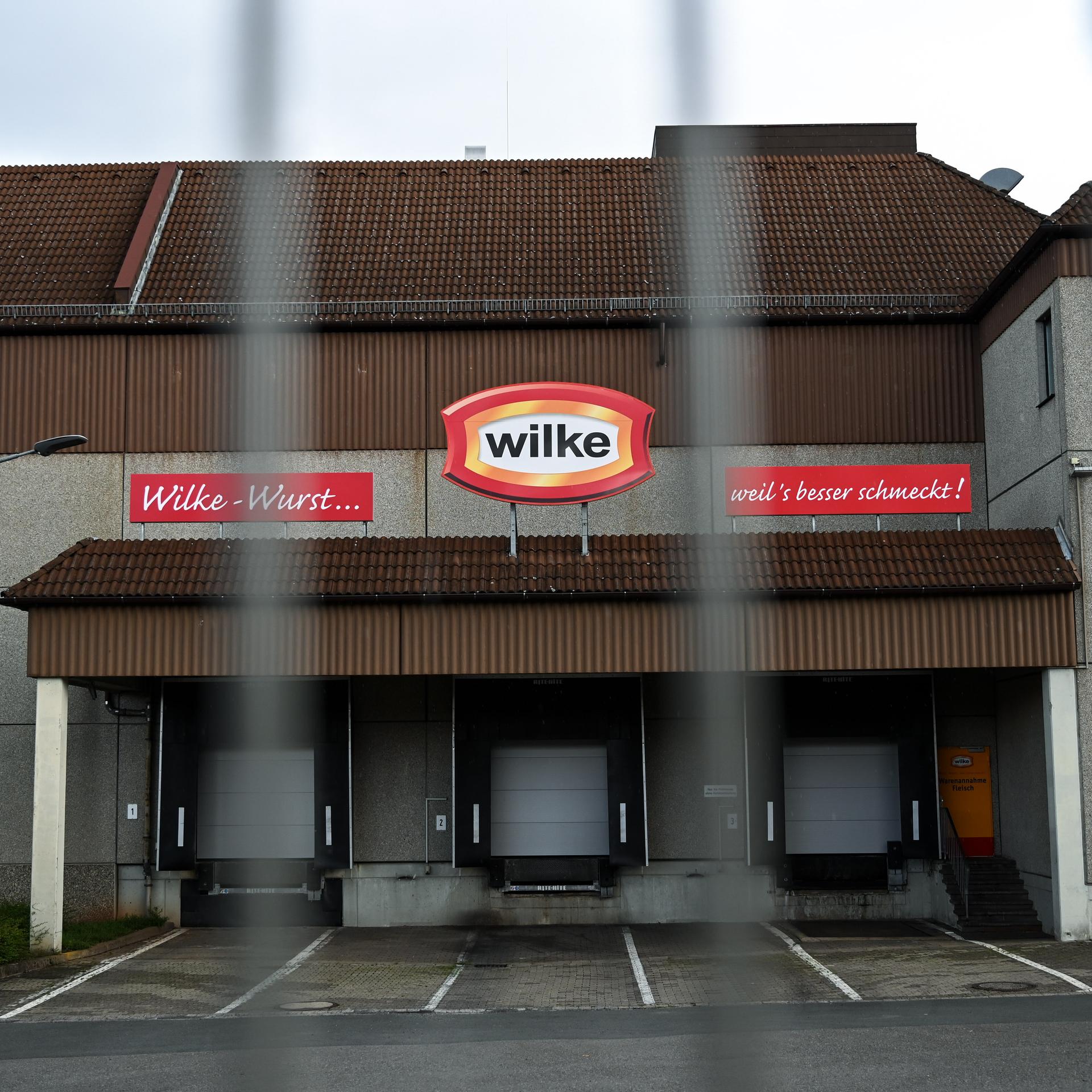 An der Fleischfabrik Wilke sind die Tore heruntergelassen, das zweckmäßige Gebäude ist durch einen Zaun fotografiert.