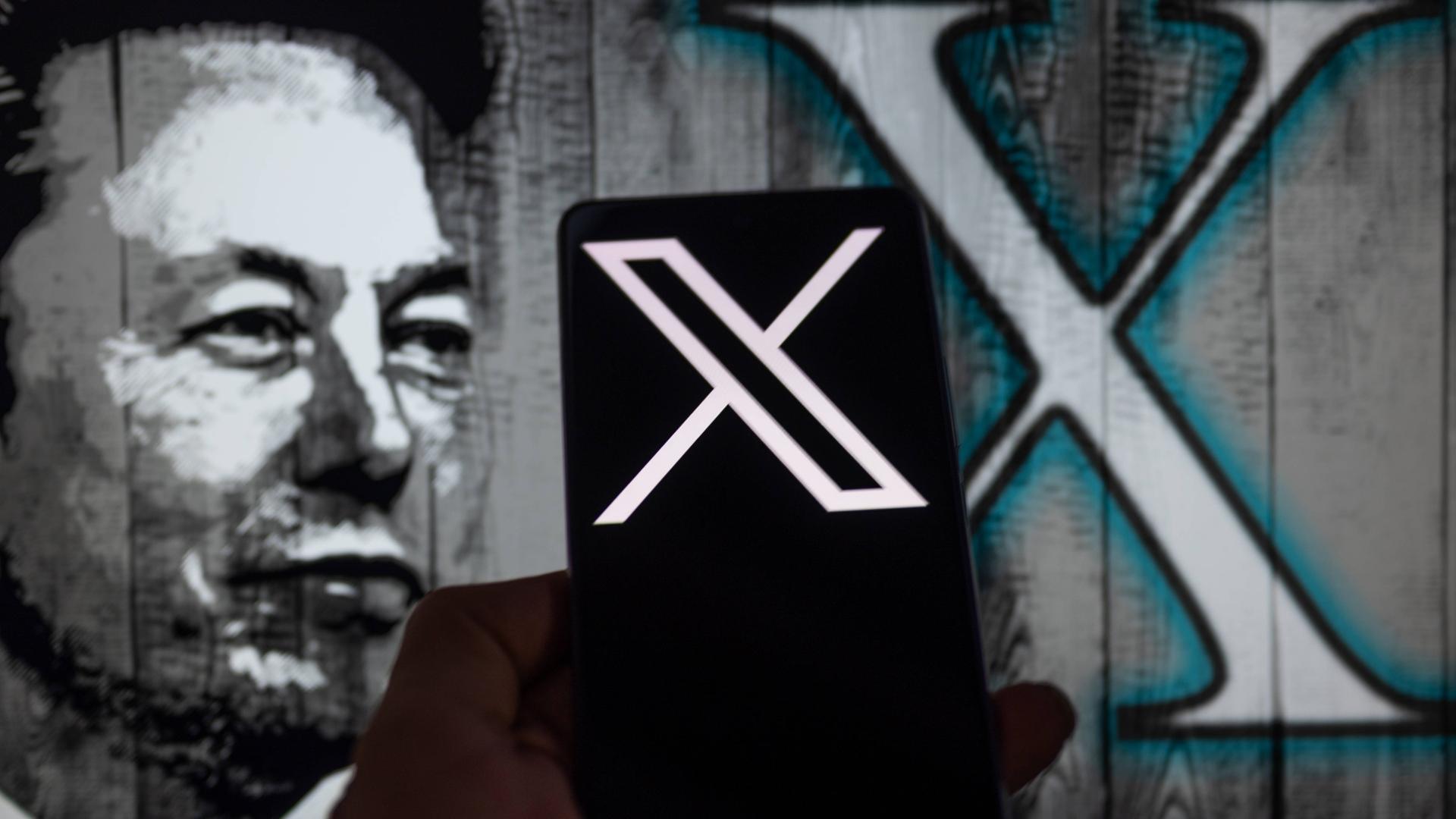 Auf einem Handybildschirm ist das X-Logo zu sehen. Im Hintergrund ist eine Illustration von Elon Musk dargestellt.