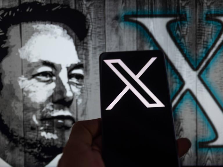 Auf einem Handybildschirm ist das X-Logo zu sehen. Im Hintergrund ist eine Illustration von Elon Musk dargestellt.