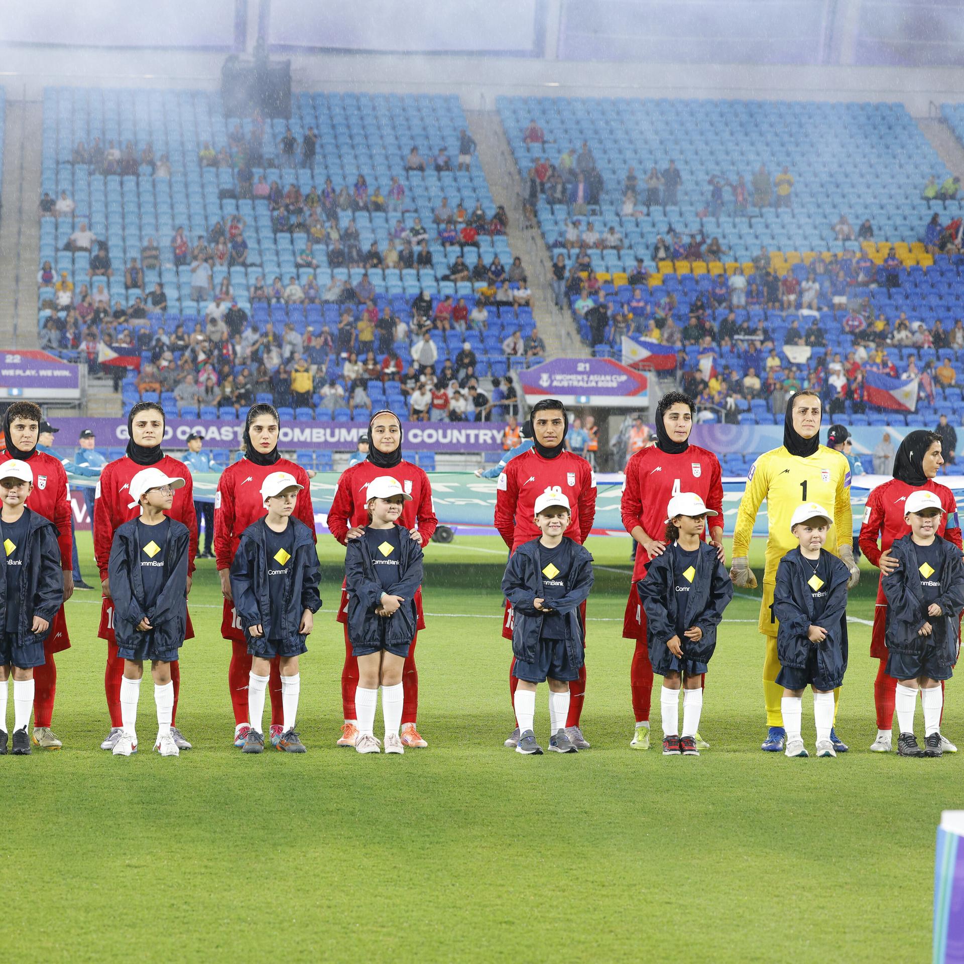Die Spielerinnen der iranischen Nationalmannschaft stehen aufgereiht vor dem Spiel auf dem Feld.
