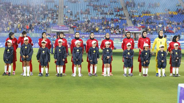 Die Spielerinnen der iranischen Nationalmannschaft stehen aufgereiht vor dem Spiel auf dem Feld.