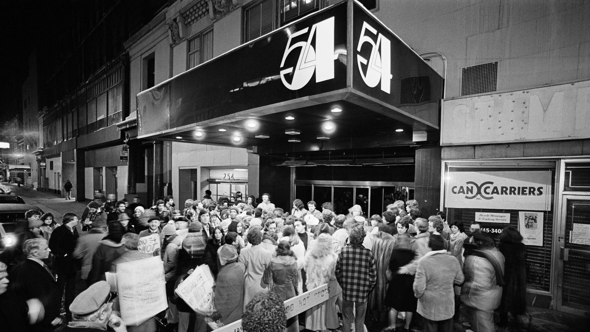 Ein Club mit der Aufschrift Studio 54, davor eine Menschenmenge.