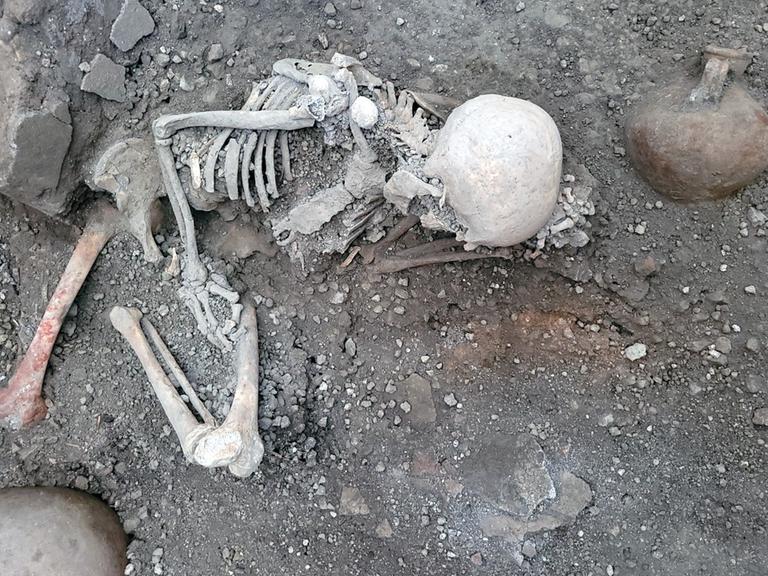 Eines der beiden Skelette, die in Pompeji gefunden wurden. Es liegt gekrümmt.