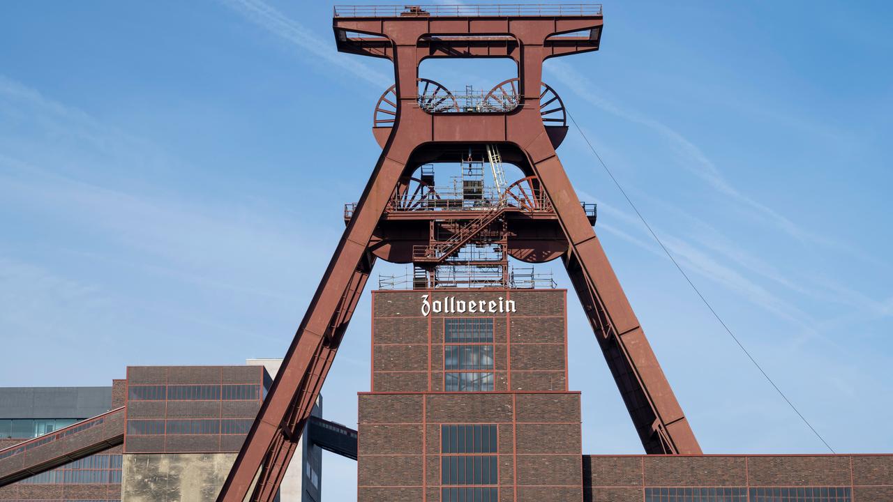 Das Doppelbock-Fördergerüst, Schacht XII, der Zeche Zollverein in Essen. Im Hintergrund blauer Himmel. 