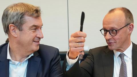 Friedrich Merz (r) und Markus Söder, CSU-Parteivorsitzender und Ministerpräsident von Bayern, reagieren bei der konstituierenden Sitzung der neuen Unionsfraktion im Bundestag nach der Unterzeichnung des Fraktionsgemeinschaftsvertrags.