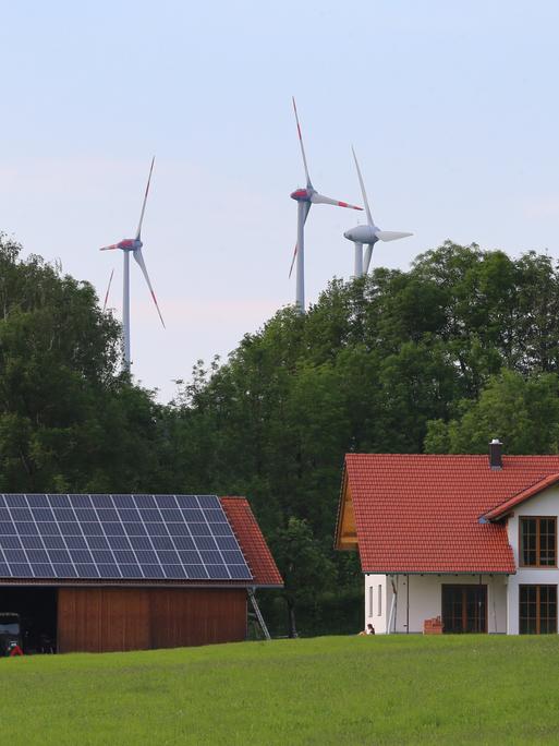 Ein Hof mit Photovoltaik in Wildpoldsried, im Hintergrund Windräder