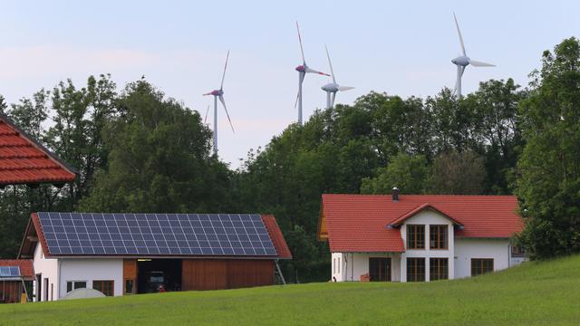 Ein Hof mit Photovoltaik in Wildpoldsried, im Hintergrund Windräder