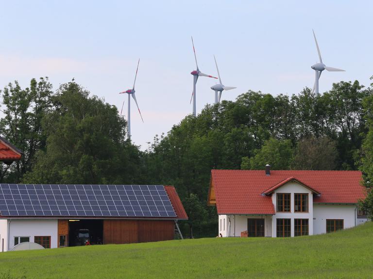 Ein Hof mit Photovoltaik in Wildpoldsried, im Hintergrund Windräder