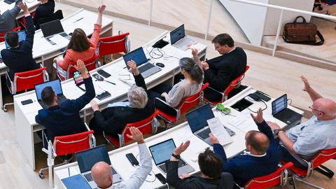 Die Fraktion vom BSW von oben fotografiert. Mehrere Personen heben ihre Hände. 