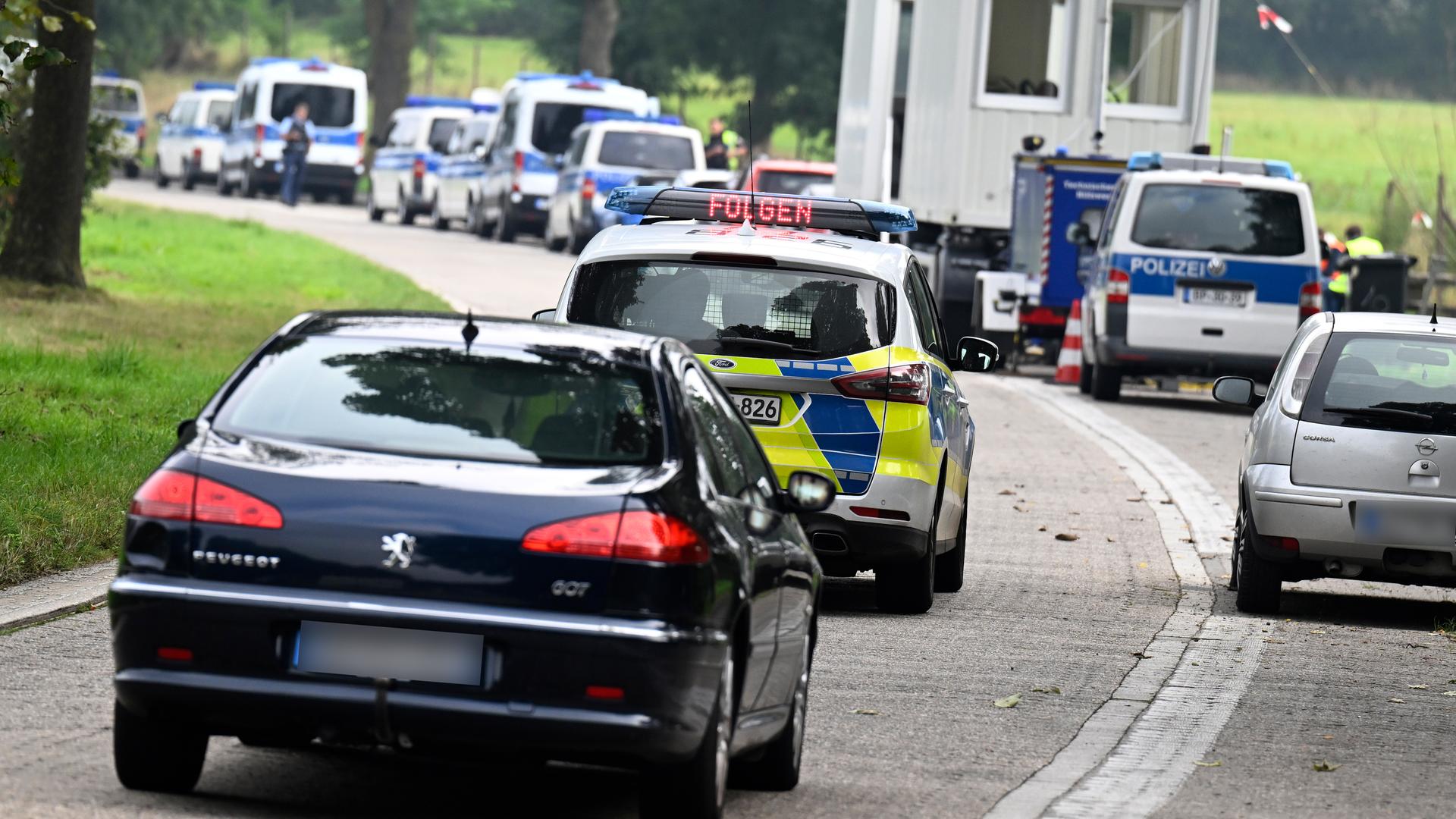 Eine Schlange von Autos an einer Grenze, darunter Fahrzeuge der Bundespolizei.