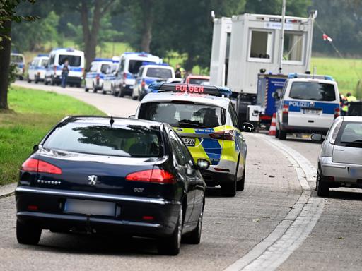 Eine Schlange von Autos an einer Grenze, darunter Fahrzeuge der Bundespolizei.
