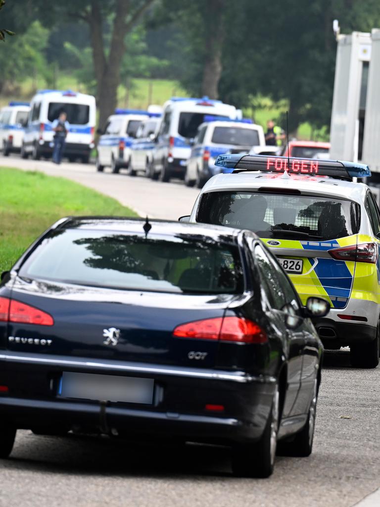 Eine Schlange von Autos an einer Grenze, darunter Fahrzeuge der Bundespolizei.