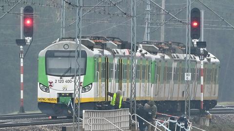 Spezialkräfte und Polizei am Tatort, an dem ein grün-weißer Zug steht 