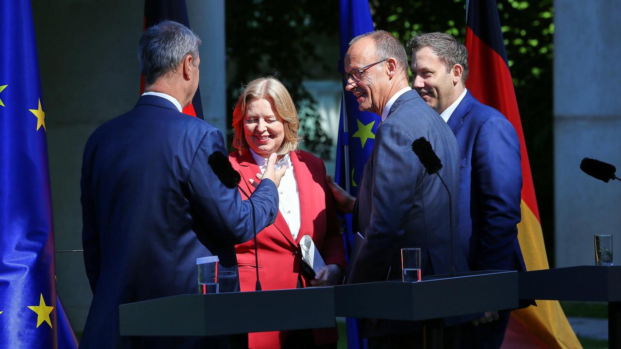 Bayerns Ministerpräsident Markus Söder (CSU), Arbeitsministerin Bärbel Bas (SPD), Bundeskanzler Friedrich Merz (CDU), Finanzminister Lars Klingbeil (SPD) schütteln sich nach einer Pressekonferenz die Hand und lächeln. 