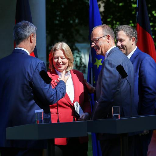 Markus Söder, Arbeitsministerin Bärbel Bas, Bundeskanzler Friedrich Merz, Finanzminister Lars Klingbeil schütteln sich nach einer Pressekonferenz die Hände und lächeln. 