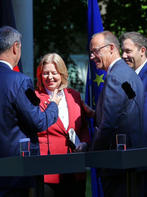 Bayerns Ministerpräsident Markus Söder (CSU), Arbeitsministerin Bärbel Bas (SPD), Bundeskanzler Friedrich Merz (CDU), Finanzminister Lars Klingbeil (SPD) schütteln sich nach einer Pressekonferenz die Hand und lächeln. 