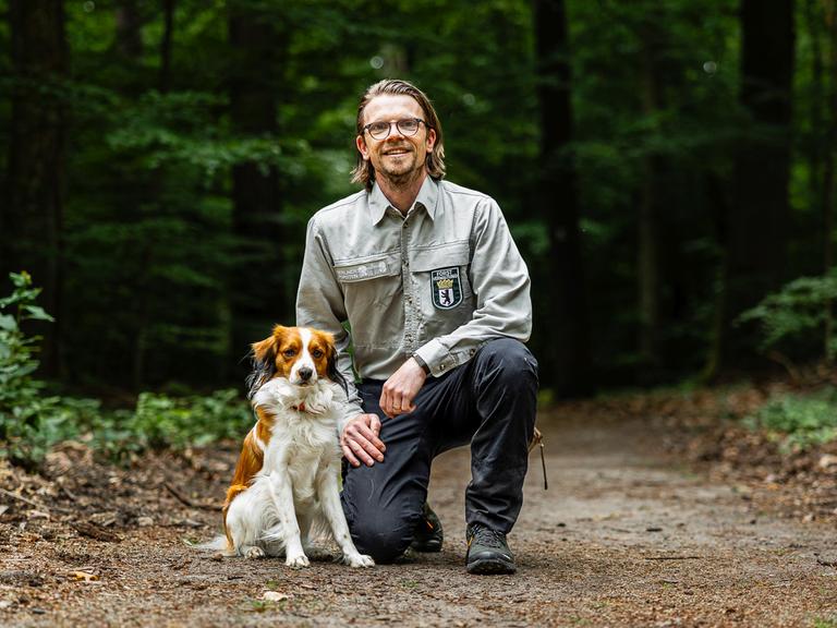 Das Bild zeigt den Revierleiter und Förster Peter Harbauer mit seinem Hund Juri.