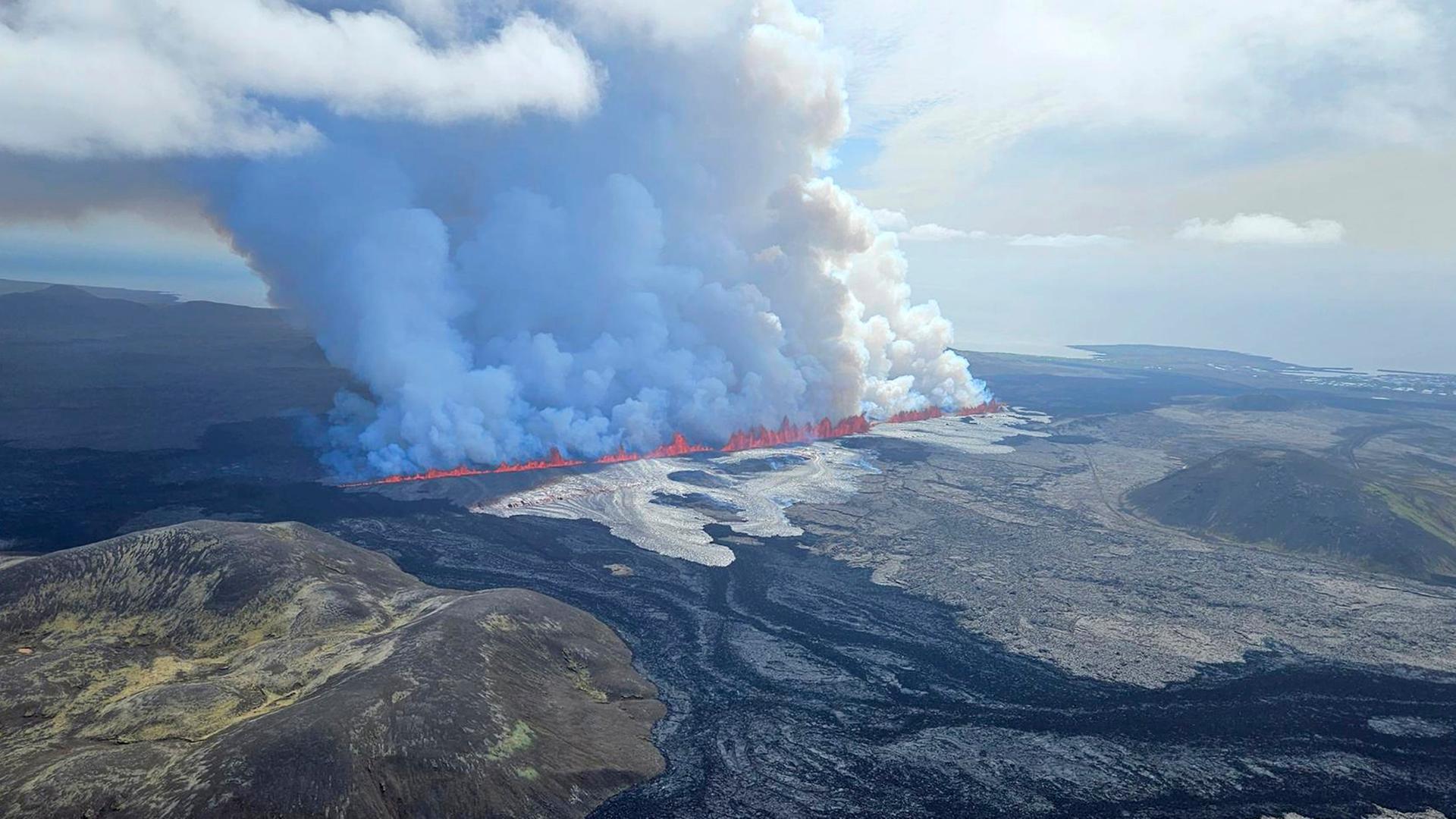Auf diesem vom Iceland Civil Defense via AP veröffentlichten Foto treten Lava und Rauch aus dem Vulkan in Grindavik aus.