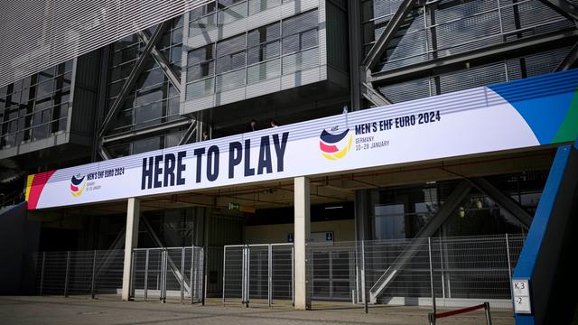 Ein Banner mit der Aufschrift "Here to Play, Men`s EHF EURO 2024" hängt vor dem Stadion in Düsseldorf