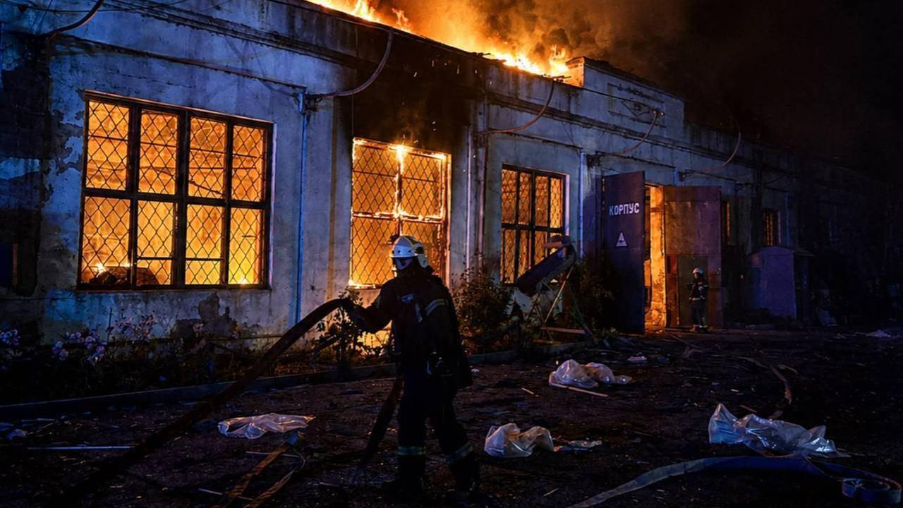 Es ist Nacht, das Gebäude brennt lichterloh. Ukrainische Feuerwehrleute versuchen zu löschen. 