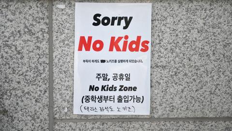 An einer Wand hängt ein Schild mit der Aufschrift "No Kids Zone".